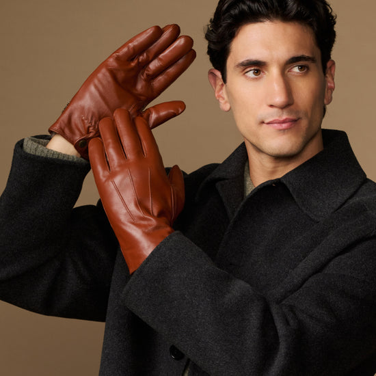 Men's dark brown leather gloves with fur lining; hand raised