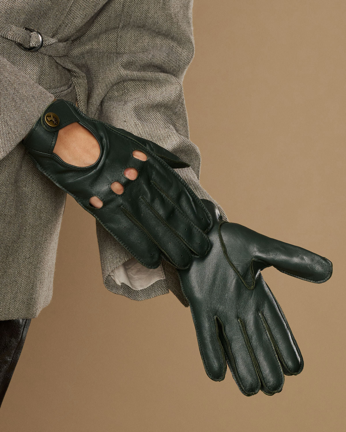 Dark green leather gloves with long open-hand cutouts and metal button detailing