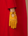 Yellow lambskin glove with oval cutout, button tab cuff and stitched fingers