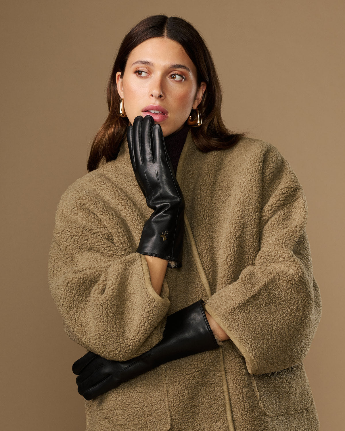 Black leather gloves with long cuffs and fur lining, touchscreen detail at palm