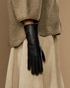 Black leather gloves with long silhouette and pointed fur-lined wrist
