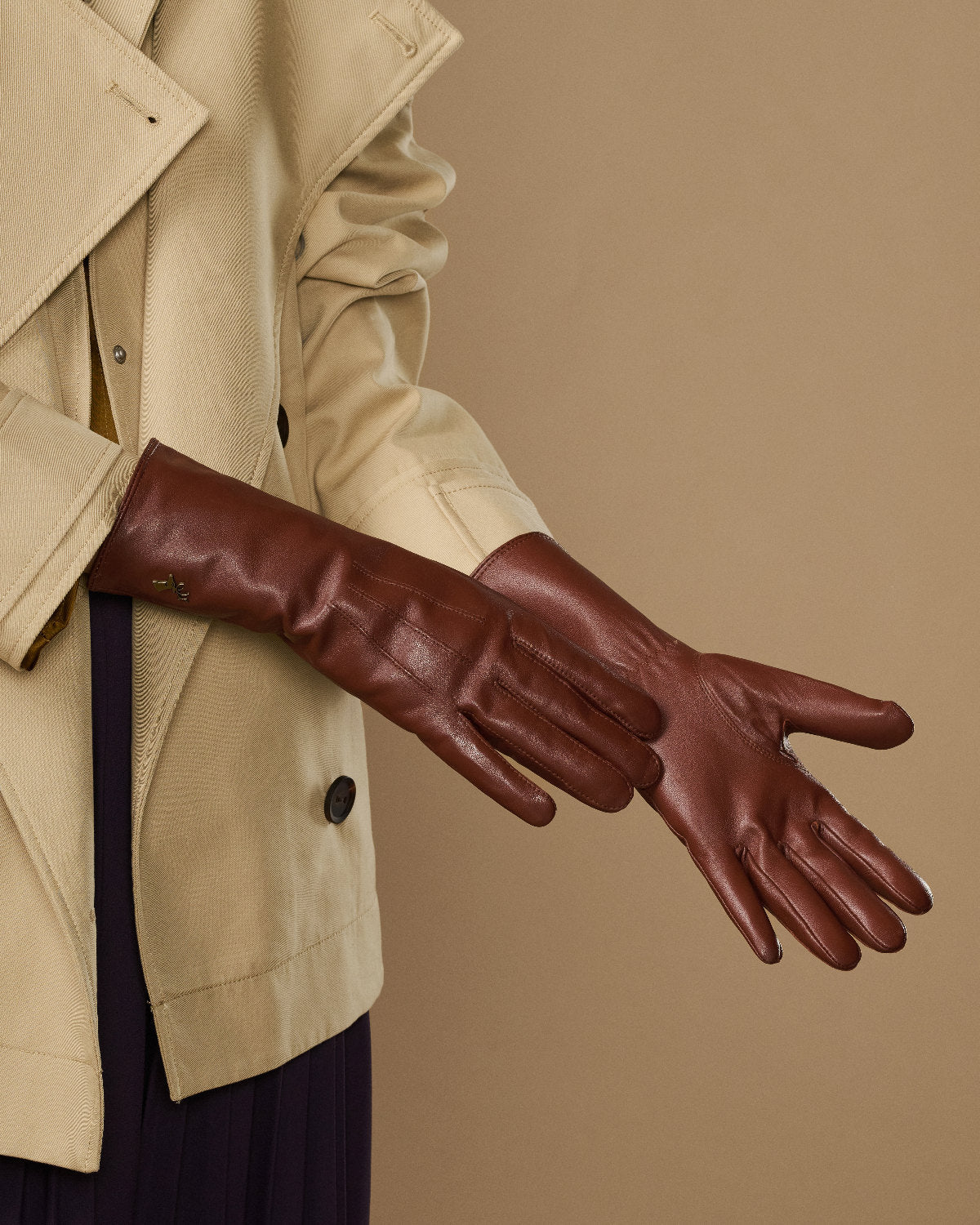 Side view of extra-long brown leather gloves with stitched knuckle seams