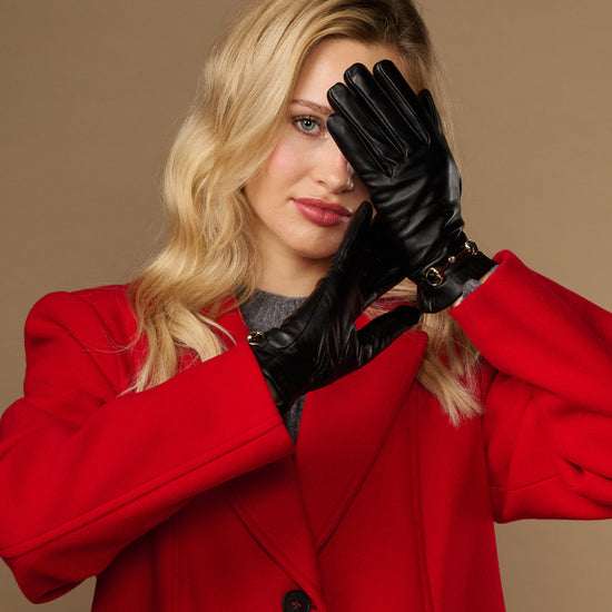 Black leather gloves worn with gold-tone buckle cuff
