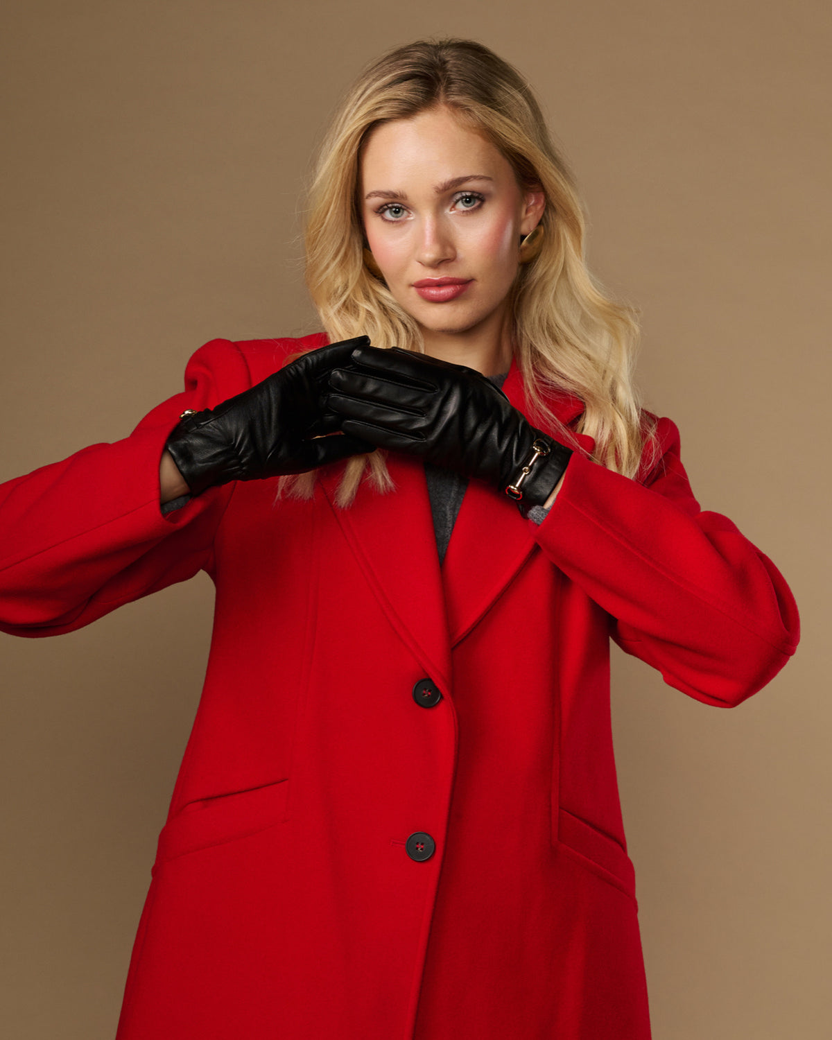 Black leather gloves with gold-tone buckle and stitched finger seams