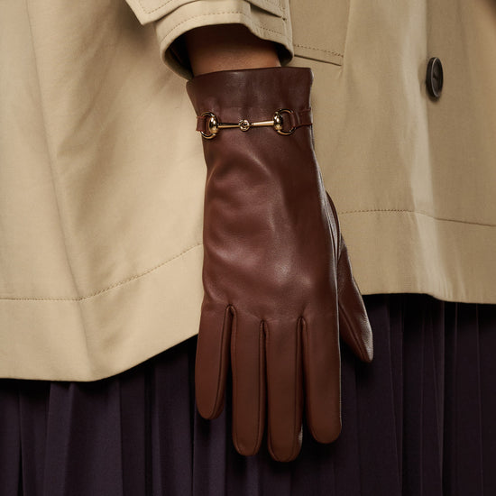 Brown leather gloves with gold-tone buckle strap and separated finger design