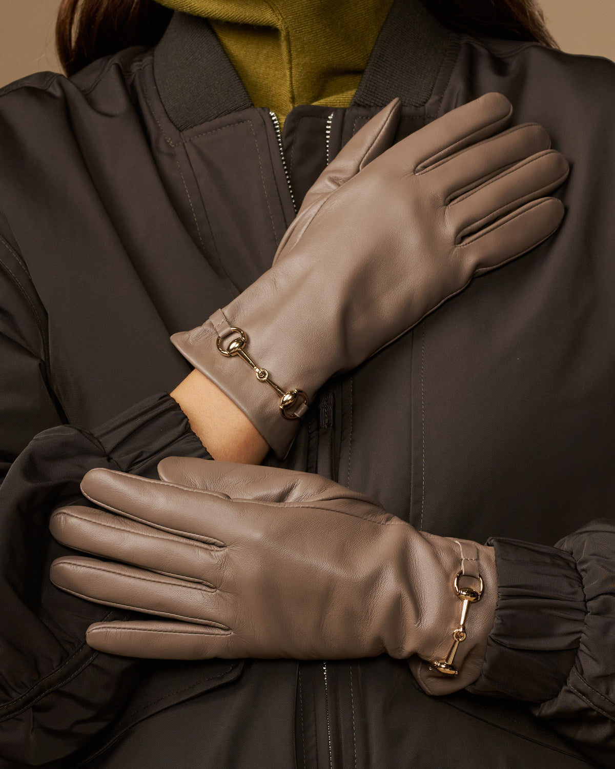 Taupe leather gloves with gold-tone buckles and smooth stitched finger design