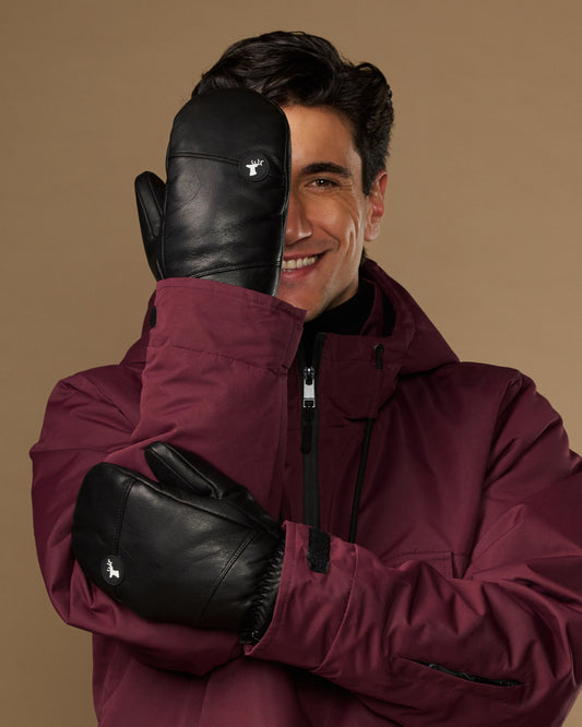 Black leather men's winter mittens, shown worn with smooth panels and small logo patches.