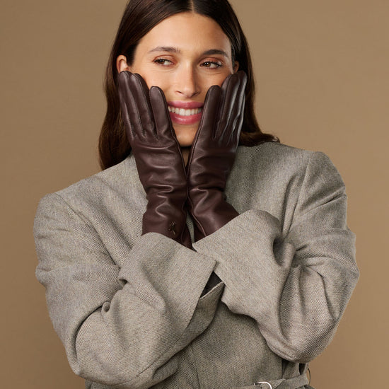Long dark brown leather gloves held together in front