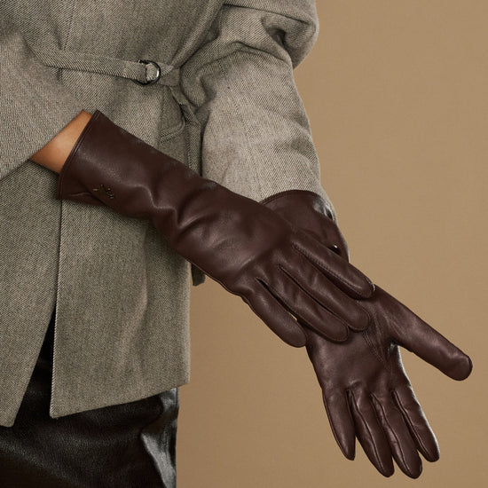Long dark brown leather glove close-up with smooth surface