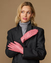 Women’s pink leather gloves crossed at chest, with small logo on the back