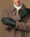 Dark green Jake sheepskin gloves with warm fleece lining, front view with crossed arms