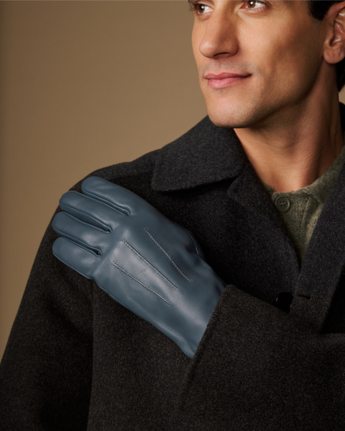 Blue sheepskin gloves worn with a dark winter coat