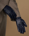 Single navy leather glove on extended hand, showing palm and finger seams