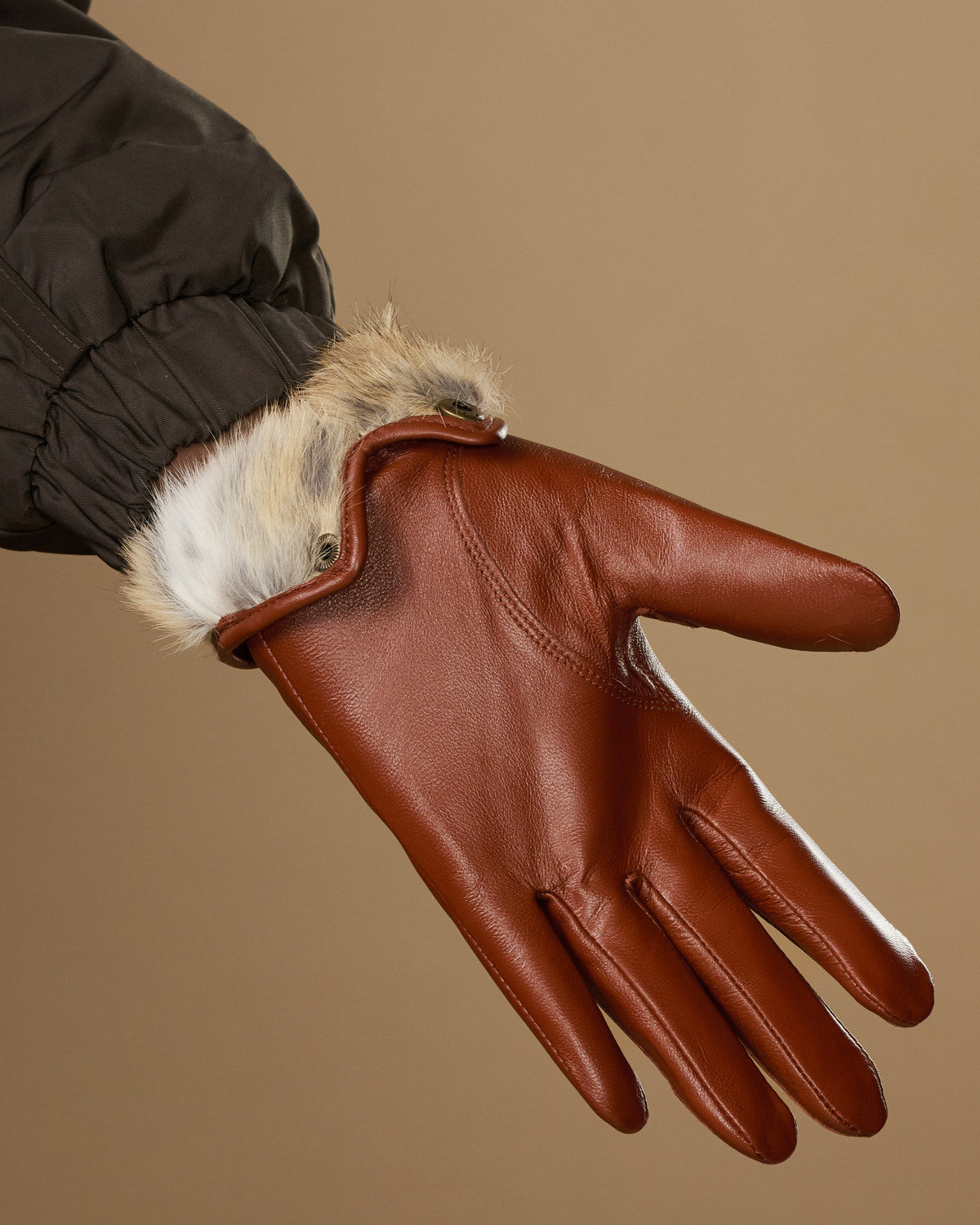 Women’s cognac leather gloves with white rabbit-fur cuff lining and finger seams