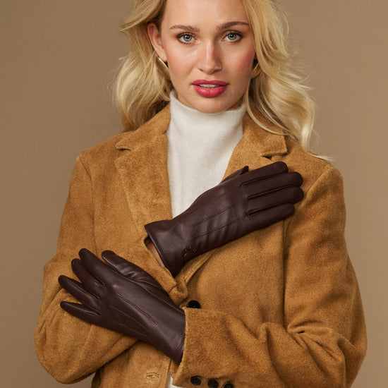 Brown fleece-lined leather gloves crossed at chest, front view