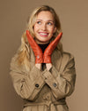 Orange sheepskin leather gloves with fleece lining, worn with hands raised near face
