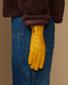 Yellow leather gloves with dark fleece cuff, shown over denim jeans