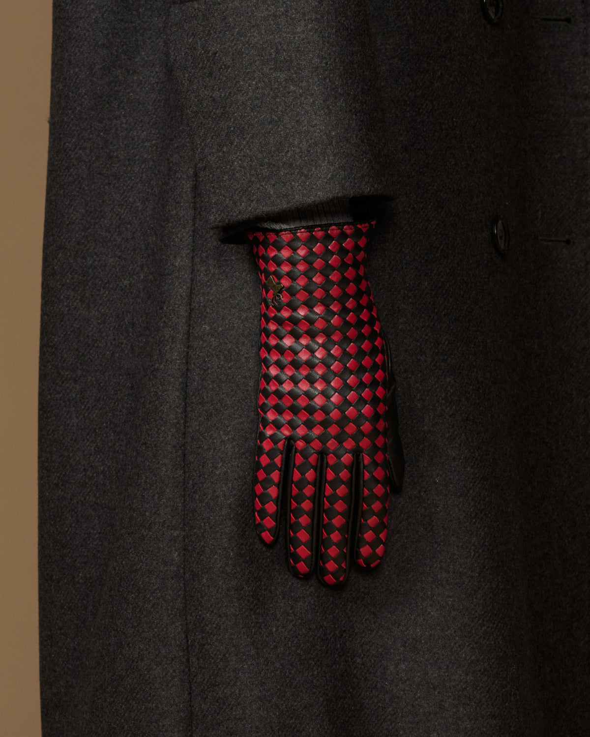 Single women's black leather glove showing red-and-black checkered back and fingers