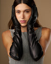 Women’s black lambskin leather elbow gloves with gathered cuff, close-up on model