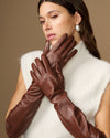 Close-up of women’s brown leather elbow gloves, fingers and cuff detail visible.
