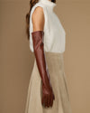 Chestnut brown leather opera glove on arm, long sleeve with fitted wrist cuff