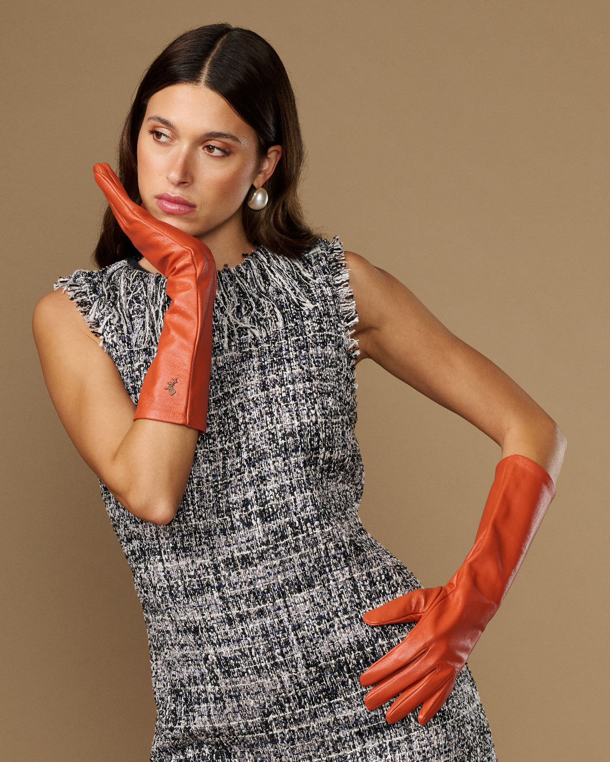 Women’s orange leather gloves with stitched emblem, palm and finger detail