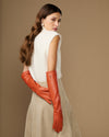 Orange leather elbow gloves shown from the side with long, fitted forearm coverage