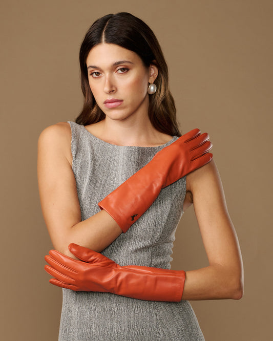 Orange mid-forearm leather gloves with smooth finish, silk lining, and touchscreen tips