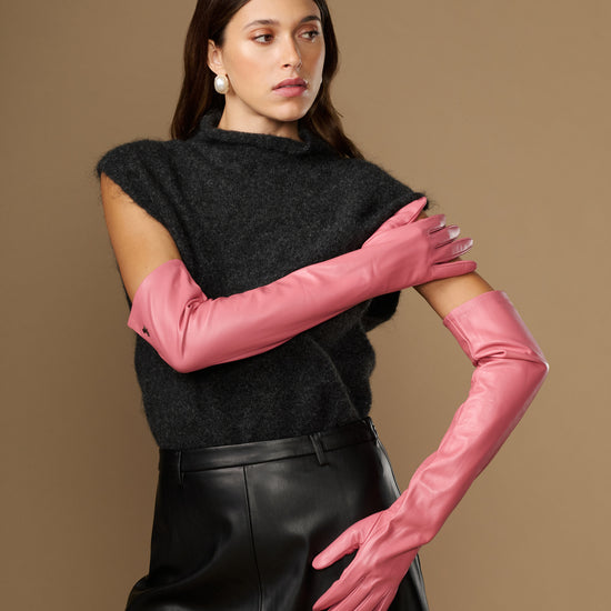 Women's pink leather gloves, one arm raised, long fitted cuff