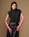 Women's pink leather gloves with long cuffs, hands resting forward