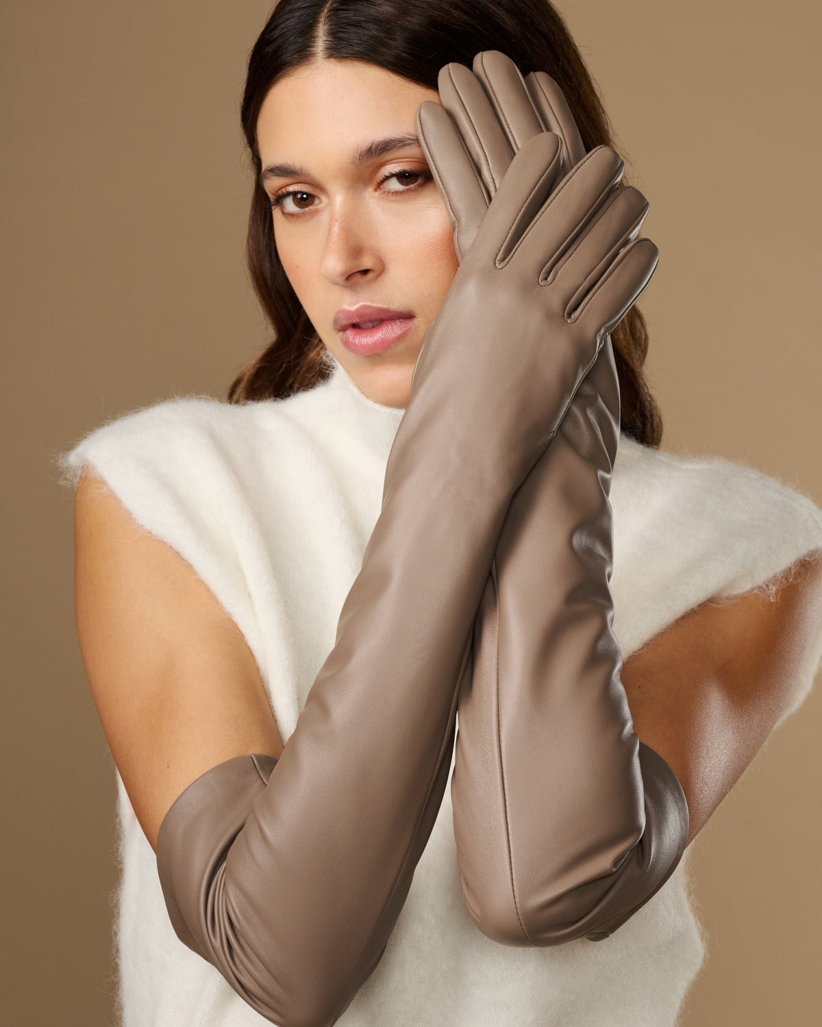 Close-up of taupe lambskin leather gloves with long cuffs and stitched fingers