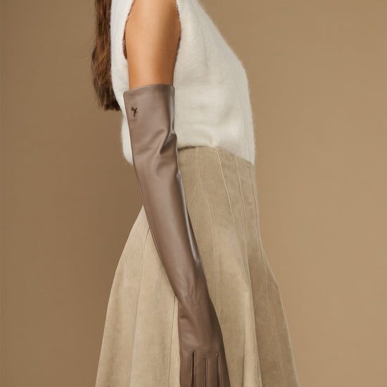 Taupe leather glove on one hand with long opera cuff and finger seams