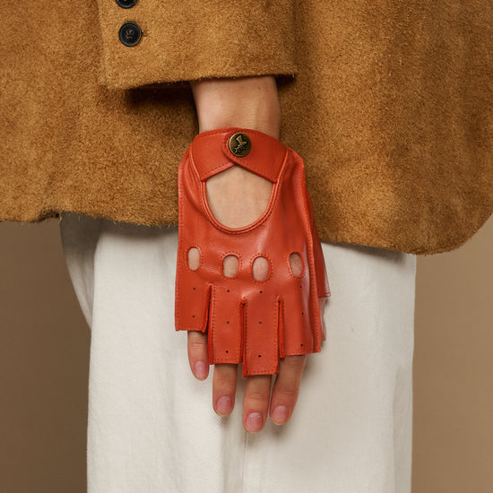 Orange fingerless glove with finger holes, thumb opening, and round logo wrist button