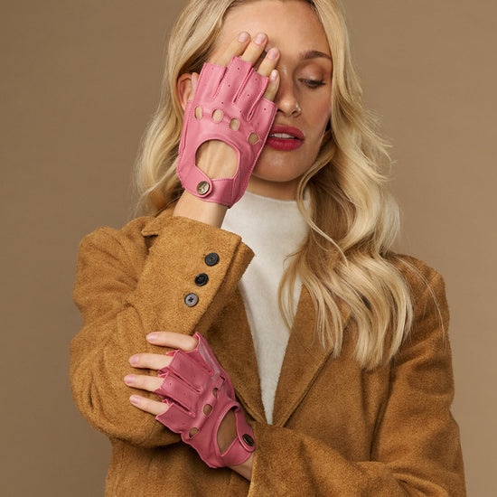 Pink fingerless lambskin driving gloves with snap closures and cutout fingers