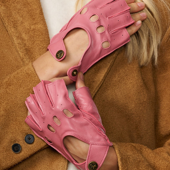 Pink fingerless driving gloves close-up with circular button details on back