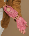 Pink fingerless lambskin driving gloves with open finger tips and stitched panels