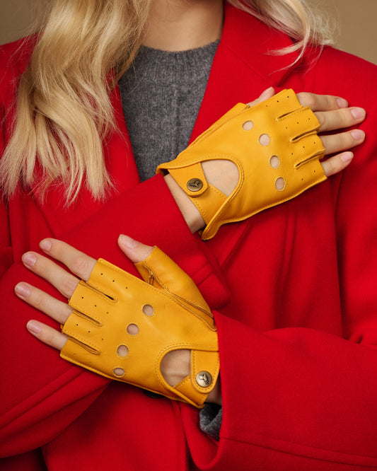 Yellow fingerless leather driving gloves with perforated knuckle detail and thumb opening