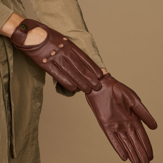 Brown leather driving gloves with stitched finger seams and perforated knuckle lines